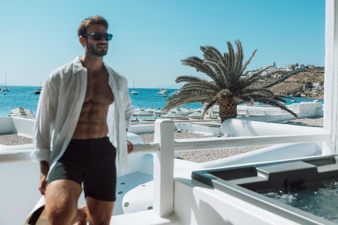 미코노스 암모스 호텔 오르노스 외부 사진 A man wearing a shirt and shorts
