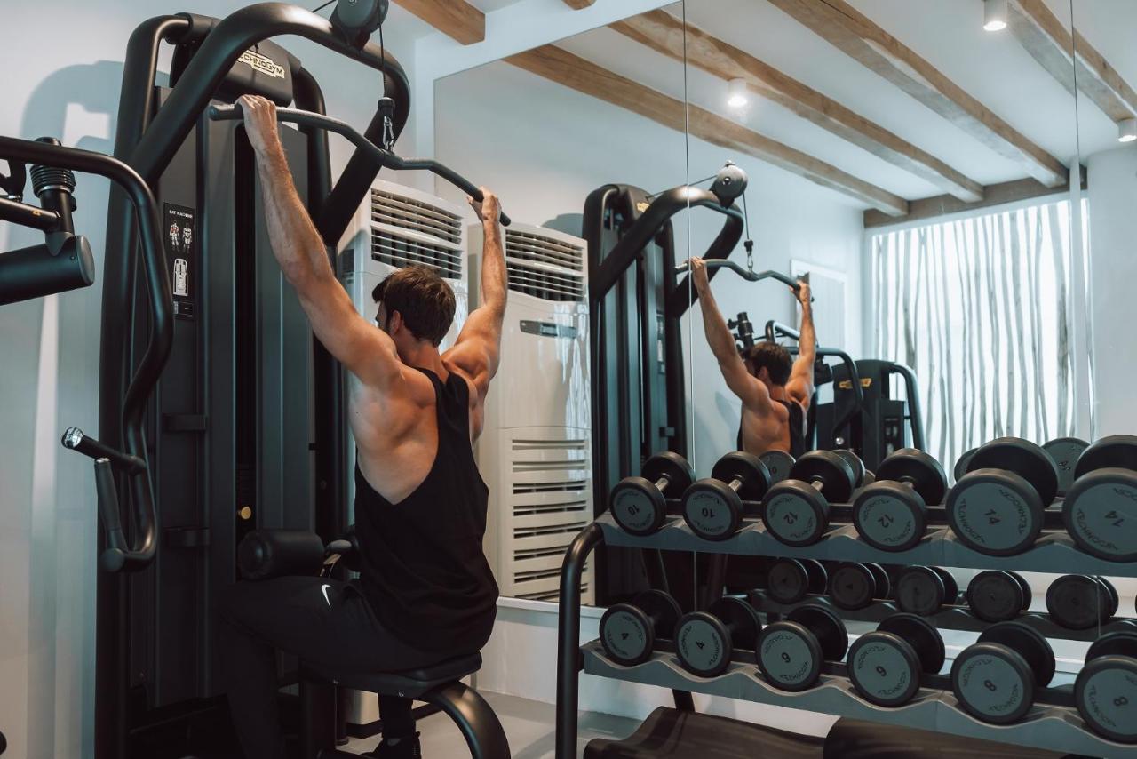 미코노스 암모스 호텔 오르노스 외부 사진 A man using a pull-up machine
